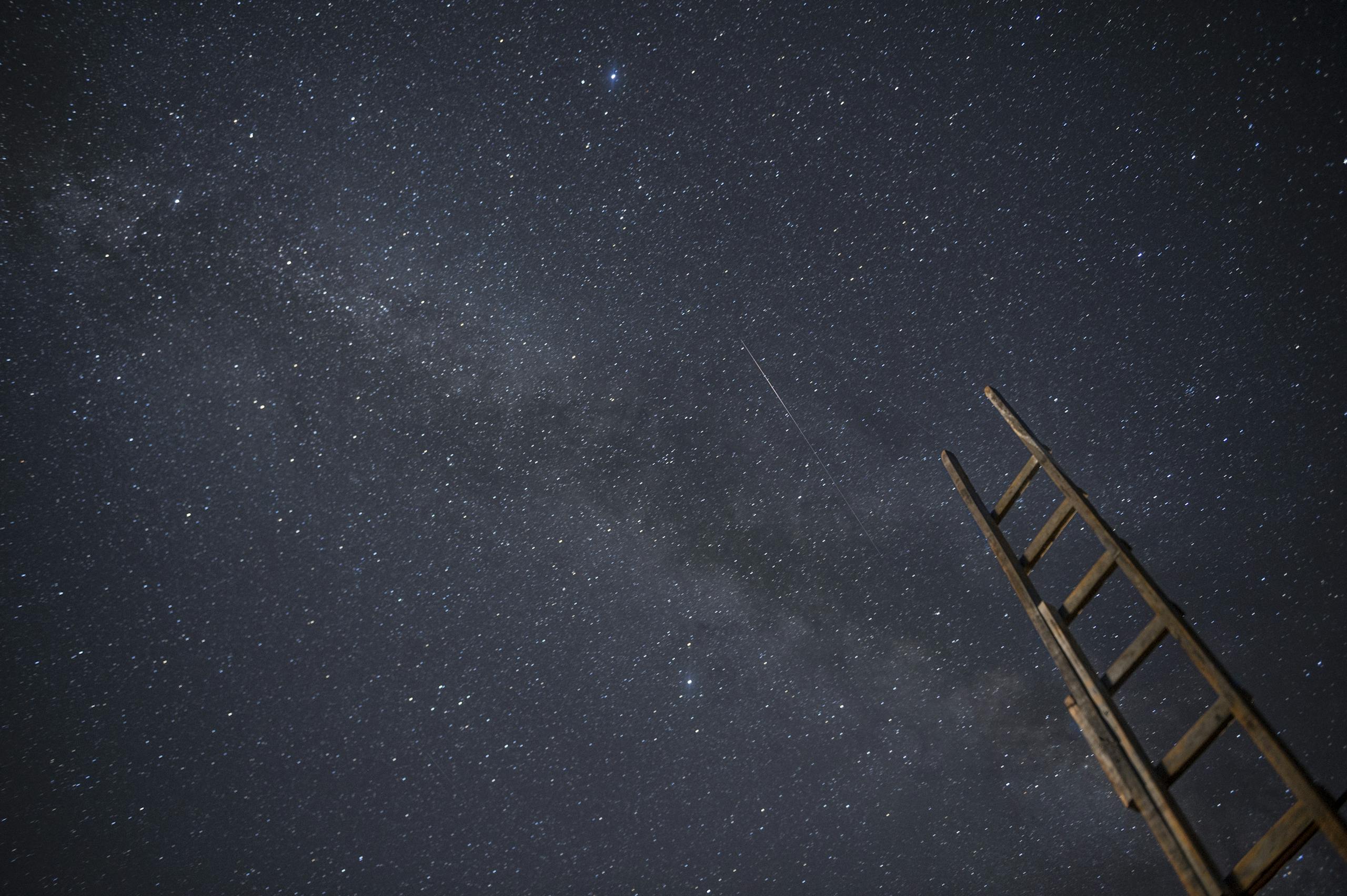 A wooden ladder under a star-filled night sky, ideal for astronomy enthusiasts.